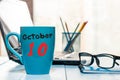 October 10th. Day 10 of month, calendar on blue tea cup at doctor workplace background. Autumn time. Empty space for
