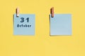 31 october. 31th day of the month, calendar date. Two blue sheets for writing on a yellow background. Top view, copy space. Autumn