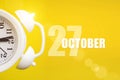 October 27th. Day 27 of month, Calendar date. White alarm clock on yellow background with calendar day. Autumn month, day of the