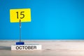 October 15th. Day 15 of october month, calendar on workplace with blue background. Autumn time. Empty space for text