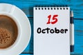 October 15th. Day 15 of month, hot coffee cup with calendar on accauntant workplace background. Autumn time. Empty space