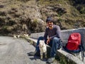 Adventurous solo traveler with cute goat companion on Uttarakhand\'s roadside. Unforgettable travel moments