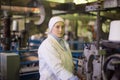 14 october 2014.Ukraine.Kyiv. The woman of average years in a white dressing gown works on a conveyor at factory of times of the