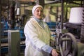 14 october 2014.Ukraine.Kyiv. The woman of average years in a white dressing gown works on a conveyor at factory of times of the