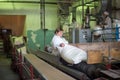 14 october 2014.Ukraine.Kyiv. The woman of average years in a white dressing gown works on a conveyor at factory of times of the