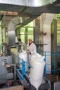 14 october 2014.Ukraine.Kyiv. The woman of average years in a white dressing gown works on a conveyor at factory of times of the