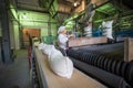 14 october 2014.Ukraine.Kyiv. The woman of average years in a white dressing gown works on a conveyor at factory of times of the