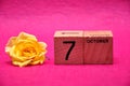 7 October on wooden blocks with a yellow rose