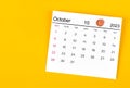 The October 2023 and wooden push pin on yellow background