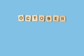October word made with wooden letter blocks on a blue background