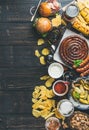 Octoberfest beer and snacks variety on dark scorched wooden background