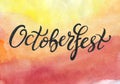 Octoberfest handwritten black ink lettering on yellow orange red watercolor background. Royalty Free Stock Photo
