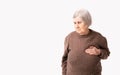 Octogenarian old lady complains of pain in her heart. She keeps her hand on her chest in the heart area. Royalty Free Stock Photo
