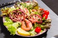 Octopus on blue plate with salad and lemon