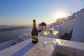 Two champagne glasses on the edge of infinity swimming pool at sunset, Santorini island.