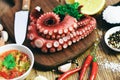 Octopus food on wooden cutting board background, cooked squid salad chili sauce seafood cuttlefish dinner restaurant, Boiled