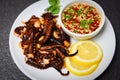 Octopus salad with lemon herbs and spices on white plate - Tentacles squid grilled appetizer food hot and spicy chilli sauce