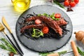 Octopus tentacles baked in garlic sauce and black pasta with cuttlefish ink. Luxury restaurant food. Seafood. Royalty Free Stock Photo