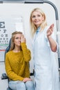 oculist gesturing while examining attractive patient