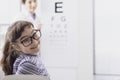Oculist testing a young patient`s eyesight using an eye chart