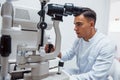 Oculist tests vision of patient by using special modern machine
