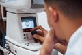 Oculist tests vision of patient by using special modern machine