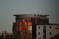 Odd round building with red and orange walls on gray sky background Royalty Free Stock Photo