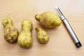 Odd shaped potatoes with potato peeler