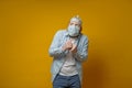 Oddball man in a medical mask is very afraid of contracting the virus, he put on a tin foil hat and looks upstairs in Royalty Free Stock Photo