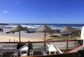 Outdoor bar terrace with straw umbrellas by the shore on Almograve beach