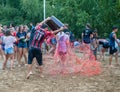 A guy pours colored water from a bucket on a girl after a water sports event at a summer camp