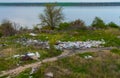 Heaps of plastic trash on the shore of the reservoir. Ecology of nature