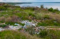 Heaps of plastic trash on the shore of the reservoir. Ecology of nature