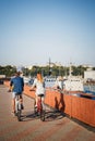 ODESSA, UKRAINE - AUGUST 06, 2015: Couple of young hipsters cycling together at the port, travel concept, summer time, back view