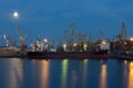 ODESSA, UKRAINE - August 2016: ship unloading at port terminal under full moon in evening with cranes containers and Royalty Free Stock Photo