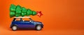 Odessa Ukraine 06 12 2019: Christmas New Year tree with red star on top of blue car toy roof. Orange color background. Creative Royalty Free Stock Photo