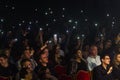 Odessa, Ukraine-circa 2019: large crowd of spectators at concert. Spectators in theater holds lighters and mobile phones at crowd Royalty Free Stock Photo
