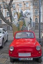 Decorated vintage red retro car with Christmas gifts on the street