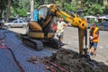 Odessa, Ukraine. July 22. 2021. A yellow excavator is digging a trench. Repair work in the city