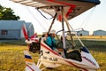 Odessa, Ukraine - July 14, 2016: Young girl with pilot preparing to start the flight at motor hang glider.