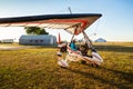 Odessa, Ukraine - July 14, 2016: Young girl with pilot preparing to start the flight at motor hang glider at small