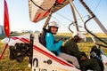 Odessa, Ukraine - July 14, 2016: Young happy girl with pilot preparing to start the flight at motor hang glider.