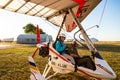 Odessa, Ukraine - July 14, 2016: Young smiling woman with pilot preparing to start the flight at motor hang glider.