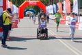 Handicapped woman in marathon on a wheelchair. Handicapped runner on marathon