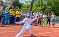 Odessa, Ukraine - June 9, 2020: Young female athlete wearing a mask and white fencing costume on the track of stadium during a