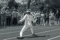 Odessa, Ukraine - June 9, 2020: Young female athlete wearing a mask and white fencing costume on the track of stadium during a