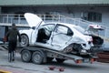 Odessa, Ukraine - March 11th 2020: Tow truck loads white smashed car after traffic accident