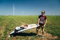 ODESSA, UKRAINE - MAY, 20 2015: Cute young hipster couple is kidding in the middle of green field with a surfboard, happy smiling Royalty Free Stock Photo