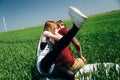 ODESSA, UKRAINE - MAY, 20 2015: Cute young hipster couple is kidding in the middle of green field with a surfboard, happy smiling Royalty Free Stock Photo