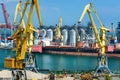 Odessa, Ukraine, May 4, 2019 - industrial seaport infrastructure, sea, cranes and dry cargo ship, grain silo, bulk carrier vessel